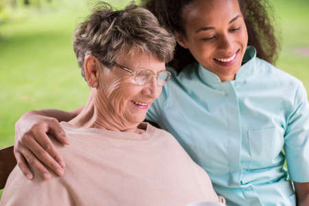 Young carer and senior woman happy togetherの写真素材