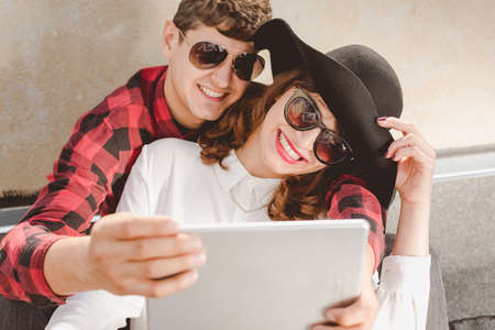 Smiling hipster couple taking a lovely photoの写真素材