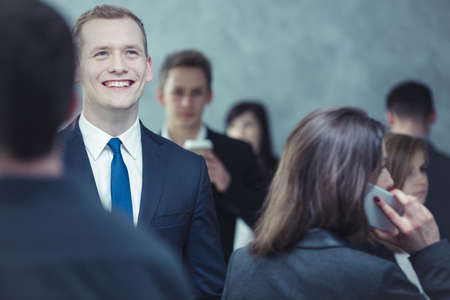 Close-up of a smartly-dressed, cheerful young man in the crowded placeの写真素材