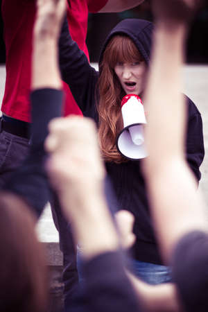 Young female rebel shouting into a megaphone