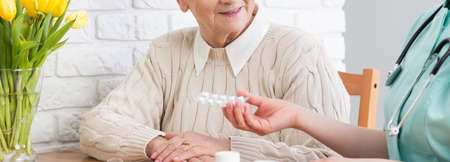 Cropped picture of a doctor giving medication to her senior patientの写真素材