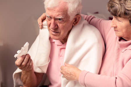 Senior woman supporting her ill, sad husband