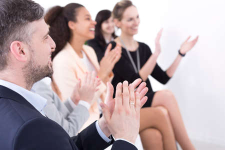 Shot of a team of businesspeople clapping hands while having a meetingの写真素材