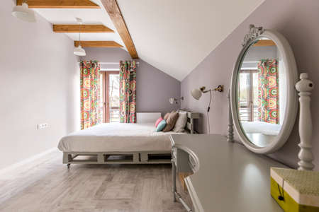 Shot of a spacious bedroom with a king-size bed and a mirrorの写真素材