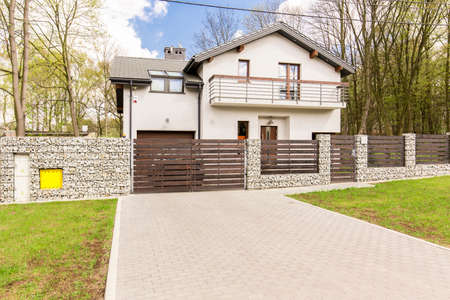 Shot of a white detached house with a driveway and a fenceのeditorial素材