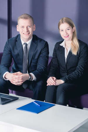 Shot of two young business partners sitting on a sofa and smiling