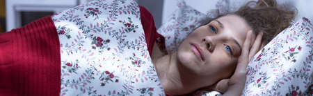 Panorama of pensive woman relaxing in her bedroomの写真素材