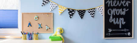 Child study area with two boards and decoration hanging on a blue wall
