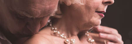 Close-up of elderly man kissing tenderly woman's back