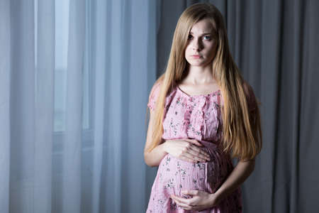 Pregnant teenage girl looking worriedの写真素材
