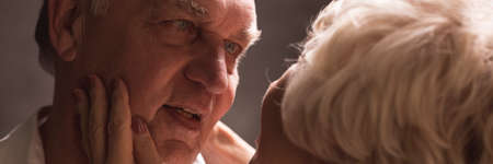 Wife holding tenderly her husband's face in her handsの写真素材