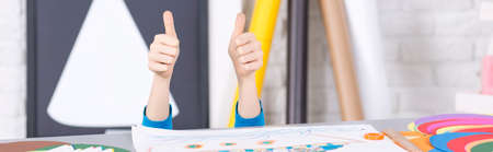 Shot of a kid showing his thumbs up