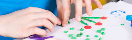 Shot of a child making a plasticine pictureの写真素材