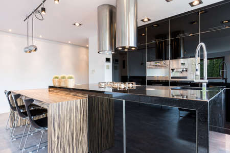 Black high-gloss open kitchen in modern styleの写真素材