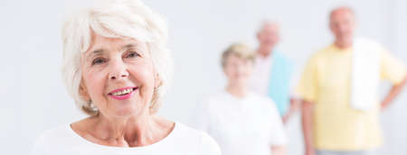 Shot of a smiling senior woman and a group of her friends standing behind her