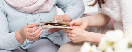 Close-up of grandmother showing granddaughter her photo albumの写真素材