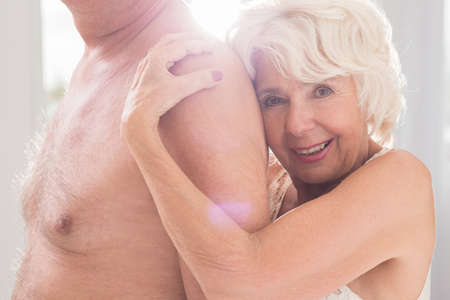 Hot mature woman embracing her sexual partner, smilingの写真素材