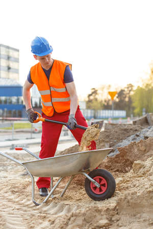 Young building worker loading a wheelbarrowの写真素材