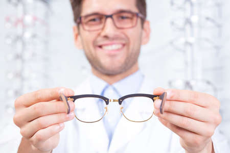 Content man optician holding a new pair of glassesの写真素材