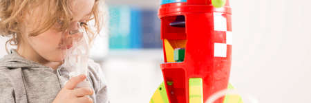 Asthmatic child problem- child taking inhalation and playingの写真素材