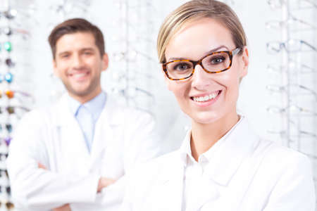 Content woman optician wearing new eyeglasses, in the background content man in a white uniformの写真素材