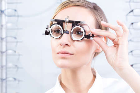 Beautiful woman having sight test at optometristの写真素材
