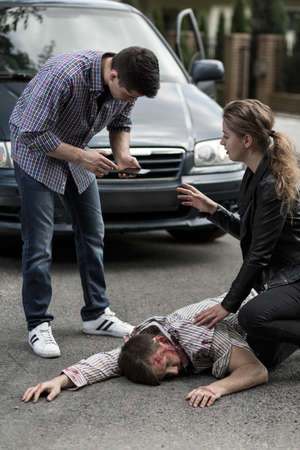 Image of people giving first aid after car collisionの写真素材