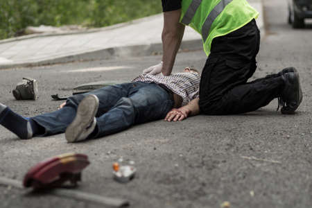 Picture of man resuscitating male car crash victim