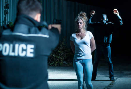 Hijacker surrendering to an armed policeman, and a young woman being rescued