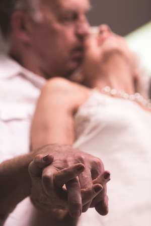 Senior man and woman touching each other hands, close upの写真素材