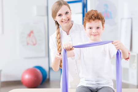 Female physiotherapist preparing her young patient to exercisesの写真素材