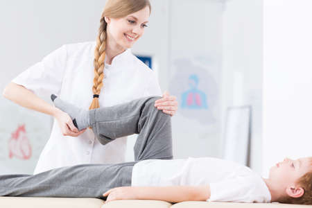 Female physiotherapist practicing with a young patient