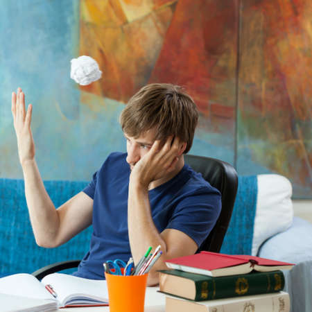 Frustraed student throwing away his notesの写真素材