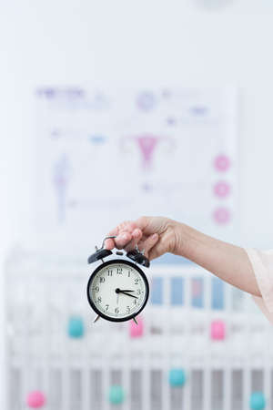 Close-up of woman's hand holding a clockの写真素材