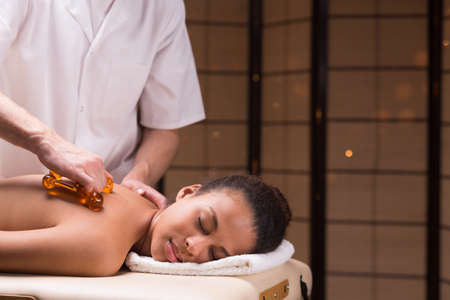 Beautiful woman lying during professional back massageの写真素材