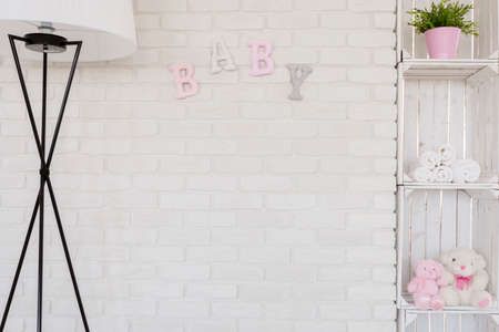 Close-up of a white brick wall in a baby room with soft decorative letters on itの写真素材