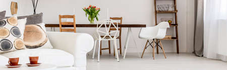 View of living room with white couch, coffee table and dining area at the backgroundの写真素材