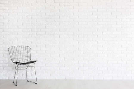 Shot of a modern gap chair against a brick wallの写真素材