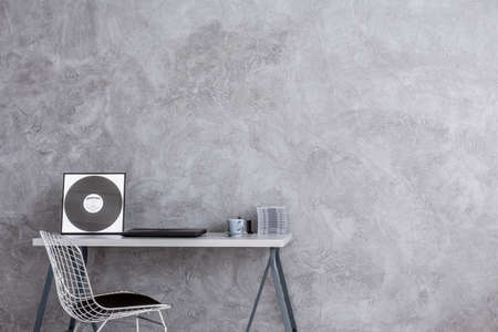 Cropped shot of a minimalistic desk facing the gray wallの写真素材