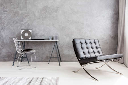 Shot of a beautiful workspace area with an elegant black armchairの写真素材