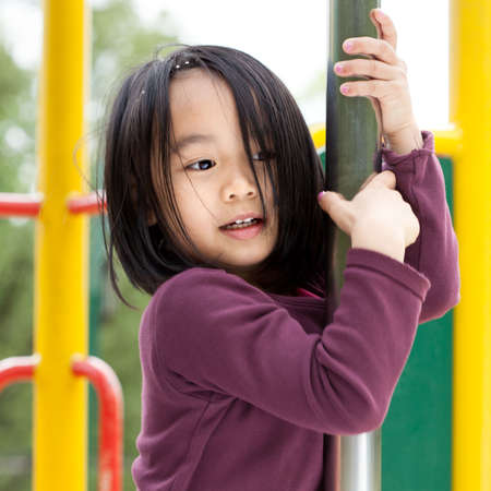 Little asian lady on a playground, vertical