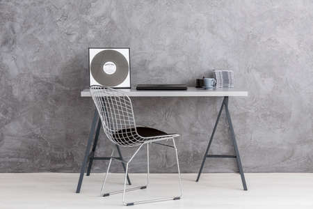 Shot of a modern desk with a stylish chair standing on a gray backgroundの写真素材