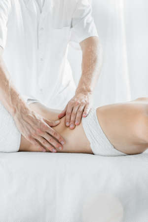 Close up of a masseur massaging woman's backの写真素材