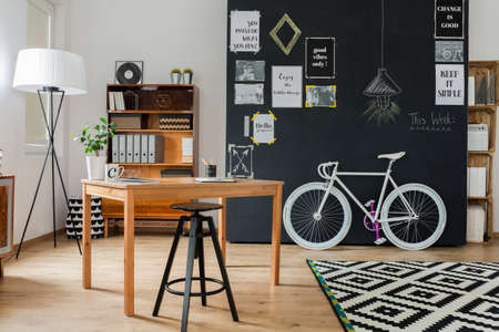 Shot of a stylish studio interior with a minimalistic workspace and a big blackboardの写真素材