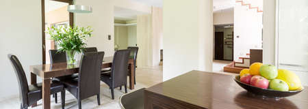 Stylish dining room with wooden table and comfortable chairs, panorama