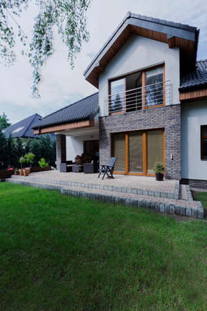 Shot of a patio made of bricks, surrounded by lots of green