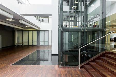 Ground floor of a modern building with glass elevator core in the middle