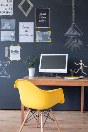 Cropped shot of an office interior with a minimalistic wooden desk and yellow chairの写真素材
