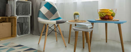 Close-up of a coffee table and a patchwork chair in a bright modern living roomの写真素材