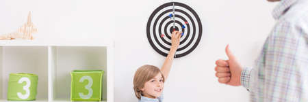 Active leisure with son- dartboard in boy roomの写真素材